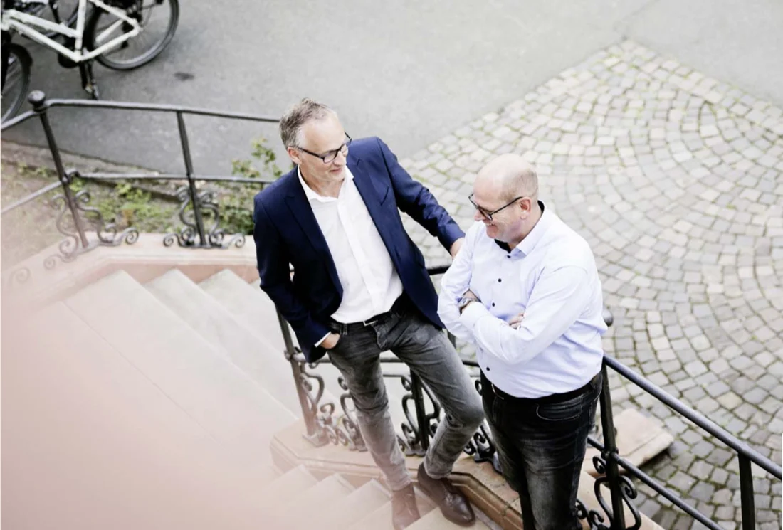 Zwei Anwälte im Gespräch auf einer Treppe